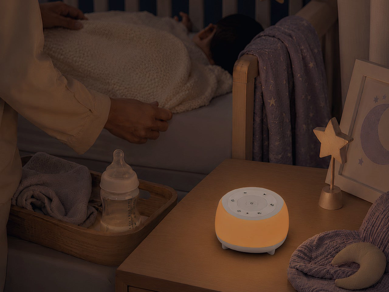 Baby sleeping in a quiet nighttime nursery with a softly glowing HEYAXA sleep device